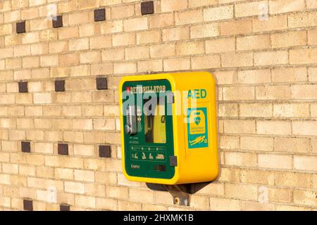 Defibrillatore semiautomatico esterno (AED) a Great Yarmouth Pleasure Beach per assistere le persone in caso di arresto cardiaco. Defibrillatore giallo e verde Foto Stock