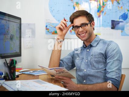 Sono entusiasta di viaggiare. Un giovane agente di viaggio che guarda un opuscolo. Foto Stock