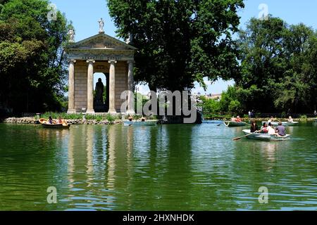 Persone che si godono Laghetto di Villa Borghese con il Tempio di Aesculapio situato su un'isola sul lago di Roma Italia Foto Stock