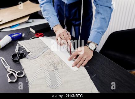 tavolo da lavoro di tailor con panno per il taglio del vestito e contrassegnato per il cucito. Foto Stock