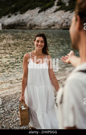 Femmina caucasica sorridente mentre cammina verso il ragazzo Foto Stock