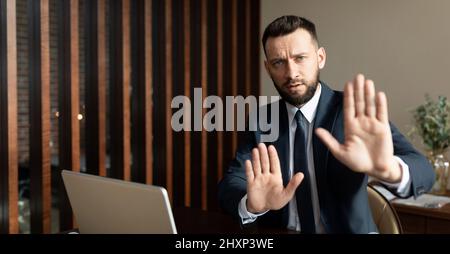 businessman rifiuta di lavorare con il partner a causa della politica di cancellazione, uomo in abito business in moderno ufficio gesturing no Foto Stock