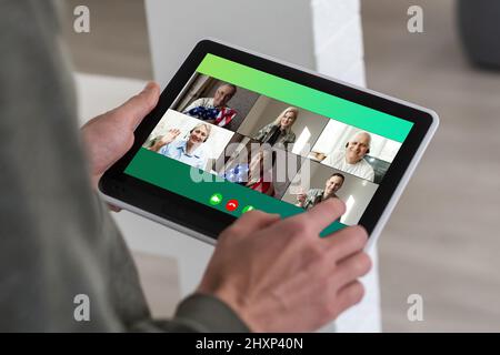 Comunicazione remota del lavoro. Businesswoman Holding Tablet avere un incontro online con il gruppo di colleghi fare videochiamata tramite computer seduto in moderno Foto Stock