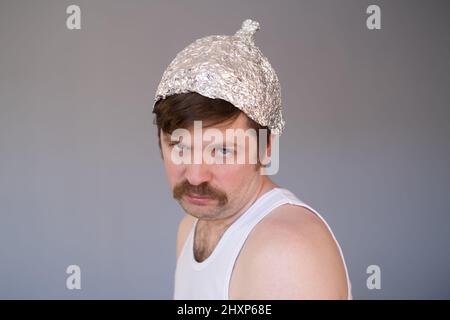 Giovane uomo in un cappuccio di lamina che ha paura e stress. Foto Stock