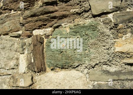 Blocchi grezzi scavati di rocce metamorfiche locali, compresi gli scisti, sono stati incorporati nella parete esterna del Castello di Beaumaris sull'isola di Anglesey Foto Stock