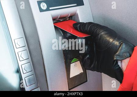 Persona inserire carta di credito di plastica in strada bancomat banca a ritirare denaro Foto Stock