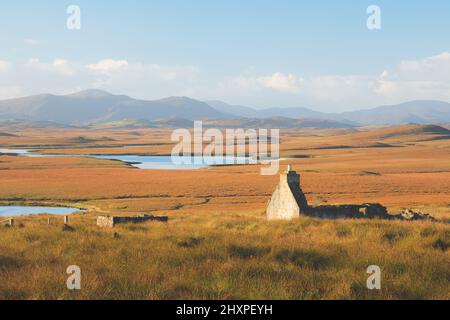 Vecchie rovine di pietra di un bothy abbandonato nel paesaggio di montagna moorland sull'isola di Lewis e Harris nelle Ebridi esterne, Scozia. Foto Stock