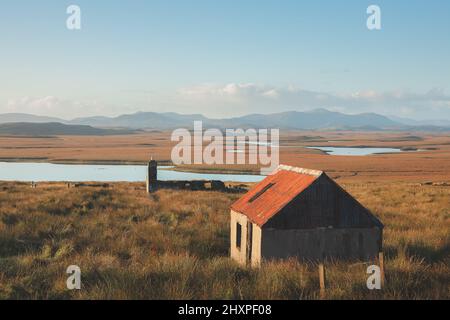 Vecchie rovine di pietra di un bothy abbandonato e cottage nel paesaggio di montagna moorland sull'isola di Lewis e Harris nelle Ebridi esterne, Scozia. Foto Stock