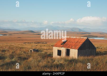 Vecchie rovine di pietra di un bothy abbandonato e cottage nel paesaggio di montagna moorland sull'isola di Lewis e Harris nelle Ebridi esterne, Scozia. Foto Stock