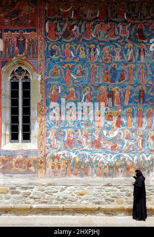 Monastero di Moldovitsa, Contea di Suceava, Moldavia, Romania: Una delle famose chiese dipinte della Moldavia. Colorati affreschi medievali e monaca. Foto Stock