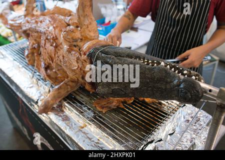 Carne di coccodrillo fritta sul barbeque. Street food. Foto Stock