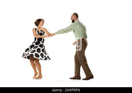 Ritratto dinamico di coppia di ballerini in abiti vintage stile retrò danza lindy hop danza isolato su sfondo bianco. Concetto di arte, azione Foto Stock