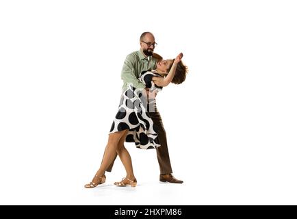 Ritratto dinamico di coppia di ballerini in abiti vintage stile retrò danza lindy hop danza isolato su sfondo bianco. Concetto di arte, azione Foto Stock