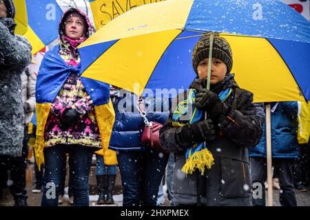 Toronto, Canada. 13th Mar 2022. Un bambino tiene un ombrello nei colori della bandiera Ucraina durante la dimostrazione. Migliaia di marzo al Consolato degli Stati Uniti per un raduno ìNo Fly Zoneî a Toronto, Canada. Le proteste globali sono state organizzate in tutto il mondo dopo Russiaís invasione dell'Ucraina. Credit: SOPA Images Limited/Alamy Live News Foto Stock