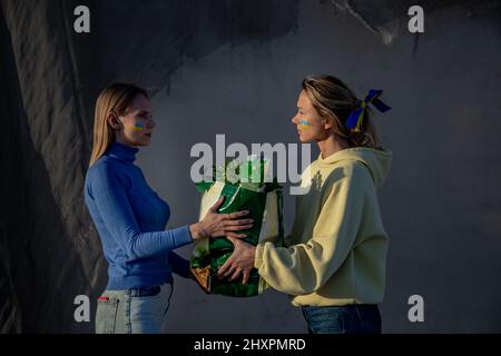 Donne ucraine che stimolano il sacco di generi alimentari uno ad un altro Foto Stock