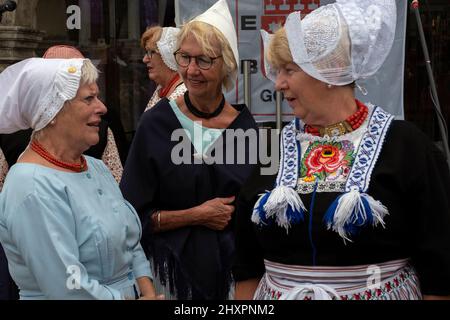 Diverse donne vestite con costumi tradizionali partecipano al mercato suonando canzoni tipiche olandesi Foto Stock