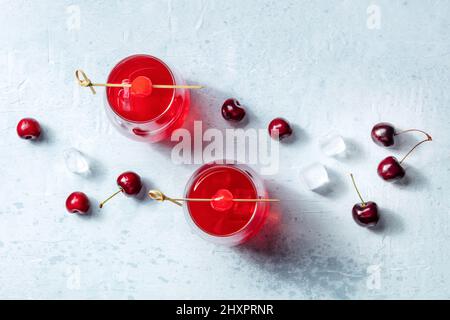 Cocktail con ciliegie e ghiaccio, shot piatto sopra la testa. Bevande alcoliche, bevande fresche estive Foto Stock