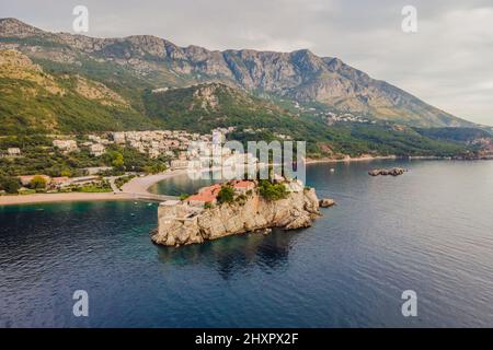 Aerofotografia. Vista dal drone volante. Vista panoramica dell'isola di Sveti Stefan a Budva in una splendida giornata estiva, Montenegro. Vista dall'alto. Bellissima Foto Stock