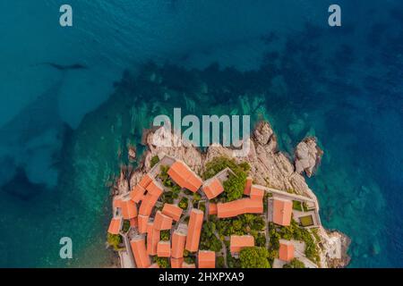 Aerofotografia. Vista dal drone volante. Vista panoramica dell'isola di Sveti Stefan a Budva in una splendida giornata estiva, Montenegro. Vista dall'alto. Bellissima Foto Stock