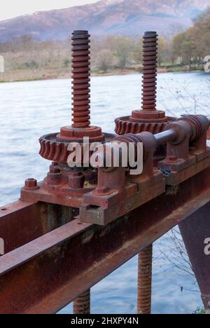 Vecchie stoppe rosse arrugginite per aprire una diga d'acqua nella valle di Ambroz Foto Stock