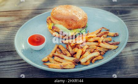 Hamburger freschi e gustosi e patatine fritte su un tavolo di legno. Primo piano Foto Stock