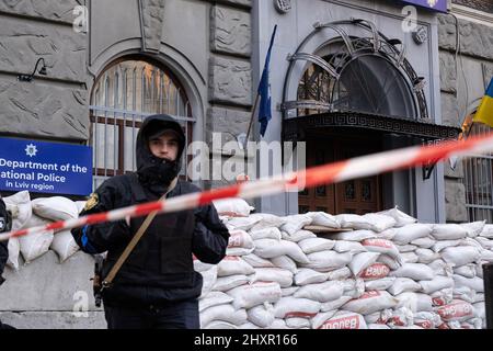 Lviv, Ucraina. 13th Mar 2022. Un ufficiale di polizia in guardia presso il dipartimento della polizia nazionale nella regione di Lviv, in quanto il luogo è coperto di sacchi di sabbia per impedirgli dal potenziale attacco aereo russo. Credit: SOPA Images Limited/Alamy Live News Foto Stock