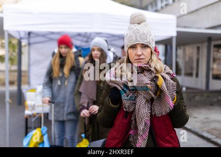 Depressa donna rifugiata Ucraina che attraversa il confine e guarda la macchina fotografica. Foto Stock