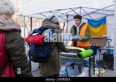 Volontari che distribuiscono coperte e altre donazioni ai rifugiati sul confine ucraino. Foto Stock