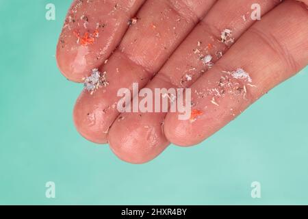 Pellet di plastica piccolo su dito. Micro plastica, problema. Foto Stock