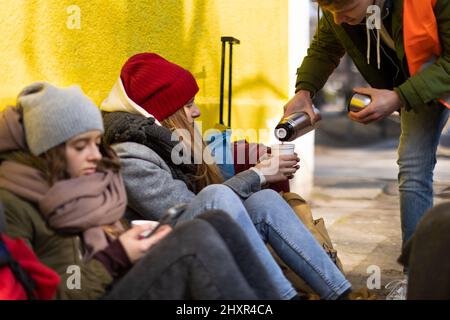 Immigrati ucraini che attraversano la frontiera e ricevono cibo e bevande da volontari. Foto Stock