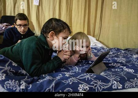 Lviv, Ucraina. 13th Mar 2022. I bambini guardano il cartone animato in un rifugio, a Lviv, in mezzo all'invasione della Russia. (Foto di Alex Chan Tsz Yuk/SOPA Images/Sipa USA) Credit: Sipa USA/Alamy Live News Foto Stock