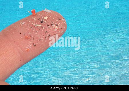 Pellet di plastica piccolo su dito. Micro plastica, problema. Foto Stock