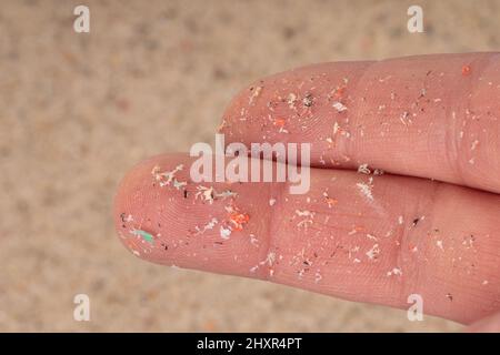 Pellet di plastica piccolo su dito. Micro plastica, problema. Foto Stock
