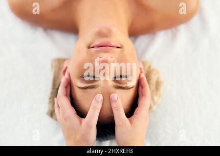 Questa è la beatitudine assoluta. Scatto di una bella giovane donna sdraiata su un tavolo da massaggio presso il centro benessere diurno. Foto Stock