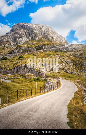 La stretta strada di passaggio di montagna si snoda attraverso l'arrampicata rocciosa su brughiere. Durmitor, Montenegro Foto Stock