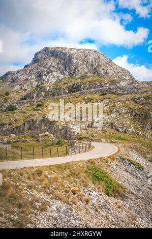 La stretta strada di passaggio di montagna si snoda attraverso l'arrampicata rocciosa su brughiere. Durmitor, Montenegro Foto Stock