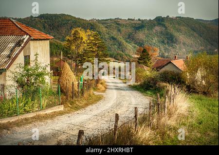 La stretta strada passa attraverso il bellissimo villaggio di montagna Foto Stock