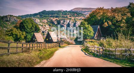 La stretta strada passa attraverso il bellissimo villaggio di montagna Foto Stock