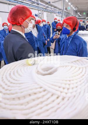 14 marzo 2022, Sassonia, Oederan: Sébastien Schaal (l), amministratore delegato, spiega la produzione presso il produttore di bastoncini di cotone Lemoine a Michael Kretschmer (r, CDU), primo ministro della Sassonia. L'azienda, che ha 100 dipendenti, si affida maggiormente alla carta anziché alla plastica per il suo imballaggio. A tal fine, nello stesso giorno è stato messo in funzione un nuovo impianto di imballaggio. I tamponi di cotone sono ora imballati in sacchetti di carta invece di sacchetti di plastica prima che siano venduti in drogherie e supermercati. Il nuovo imballaggio è realizzato con carta riciclata al 100% ed è prodotto interamente in Sassonia. Secondo la Foto Stock