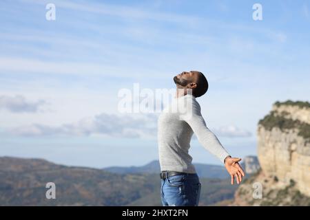 Ritratto laterale di un uomo con pelle nera che respira aria fresca in natura Foto Stock