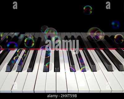 Bolle iridescenti fluttuanti su una tastiera a piano Foto Stock