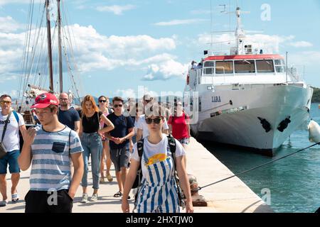 Vodice, Croazia - 25 agosto 2021: Giovani a piedi dalla nave ormeggiata Jadrolinija sul molo Foto Stock