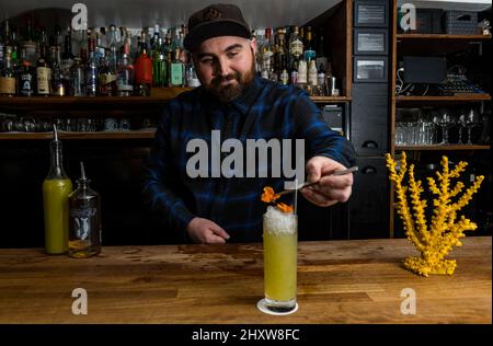 Edimburgo, Scozia, Regno Unito, 14th marzo 2022. Edinburgh International Science Festival percorso cocktail a tema climatico: Da marzo 19th le persone possono "brindare a Gaia" su un percorso di bevande autoguidato che include 17 bar e ristoranti che propongono un cocktail nuovo, a tema climatico e sostenibile. Il percorso evidenzia il lavoro che l'industria delle bevande in Scozia sta facendo per affrontare le questioni climatiche. Nella foto: Sam Baxendale of Bramble Bar & Lounge offre un cocktail con rum Seawolf, piselli da giardino, cetrioli fermentati e miele Foto Stock