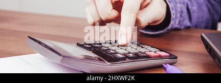 Pressione manuale della calcolatrice su una scrivania. Foto Stock