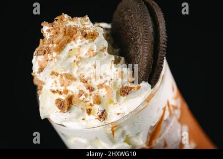 Frullato di caramello su sfondo nero. Foto Stock