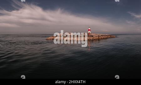 Bella scena del faro di Muglins nella Repubblica d'Irlanda contro un cielo grigio sera Foto Stock