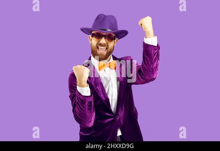 L'uomo eccitato in costume divertente che celebra il suo successo, gridando Sì e pugno pompando Foto Stock