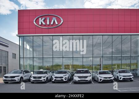 Mosca Regione, Russia - Settembre 2021: Costruzione di KIA MOTORS car selling and service center. Logo KIA sullo showroom dell'auto. Nuove auto in fila all'aperto. Foto Stock