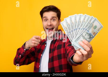 Giovane eccitato che tiene un sacco di soldi in contanti Foto Stock