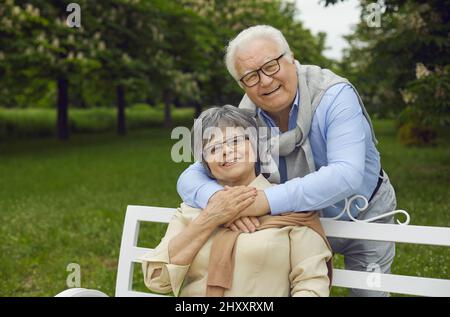 Anziani uomo e donna felici sono riposati nel parco su una panca, respirando aria fresca Foto Stock